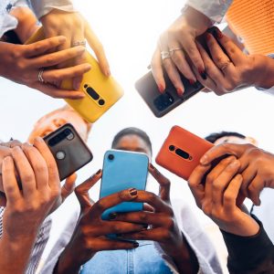 Teens in circle holding smart mobile phones